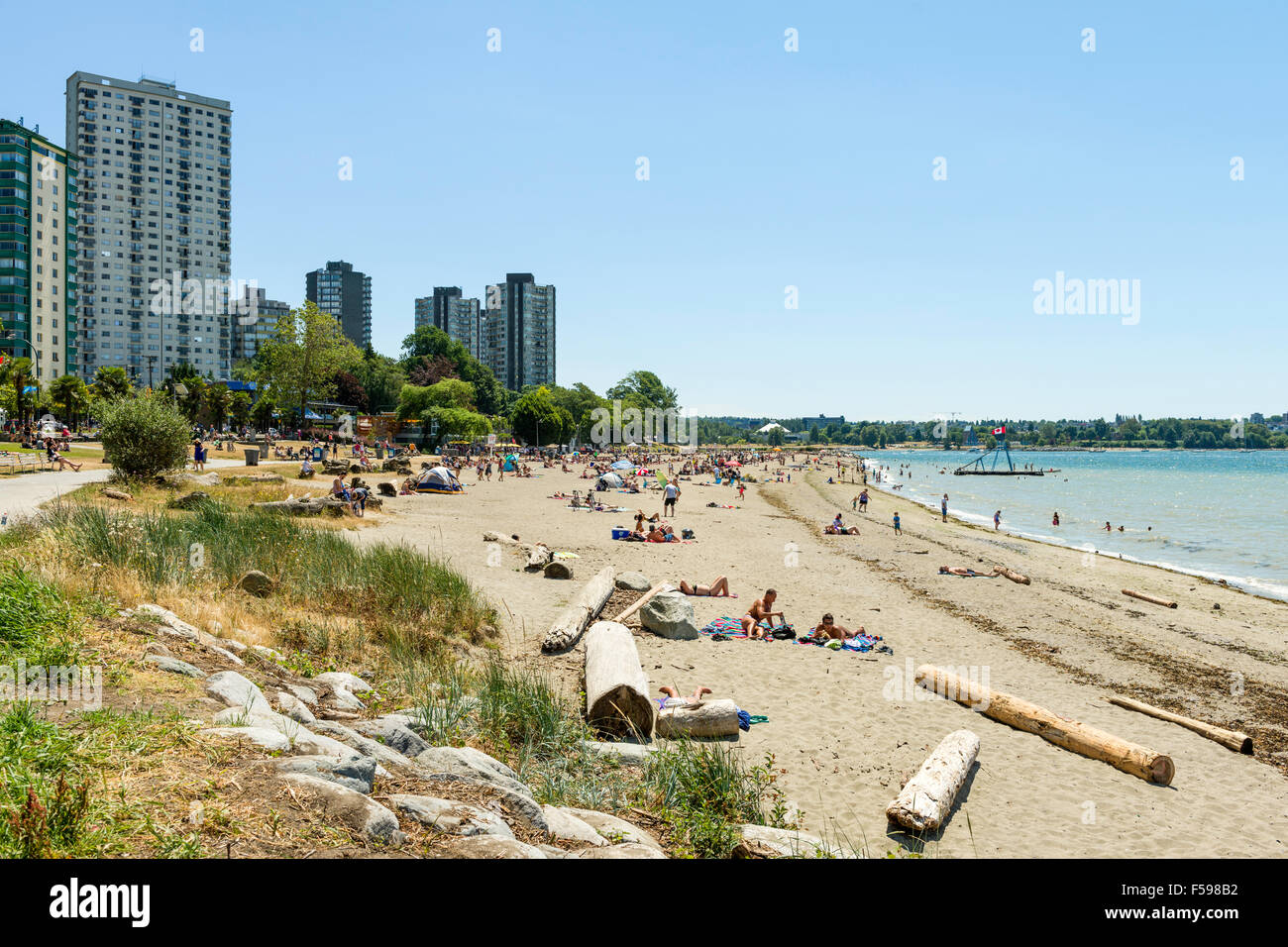 Sonnenanbeter und Badegäste am Strand von English Bay in Vancouver, BC, Kanada Stockfoto