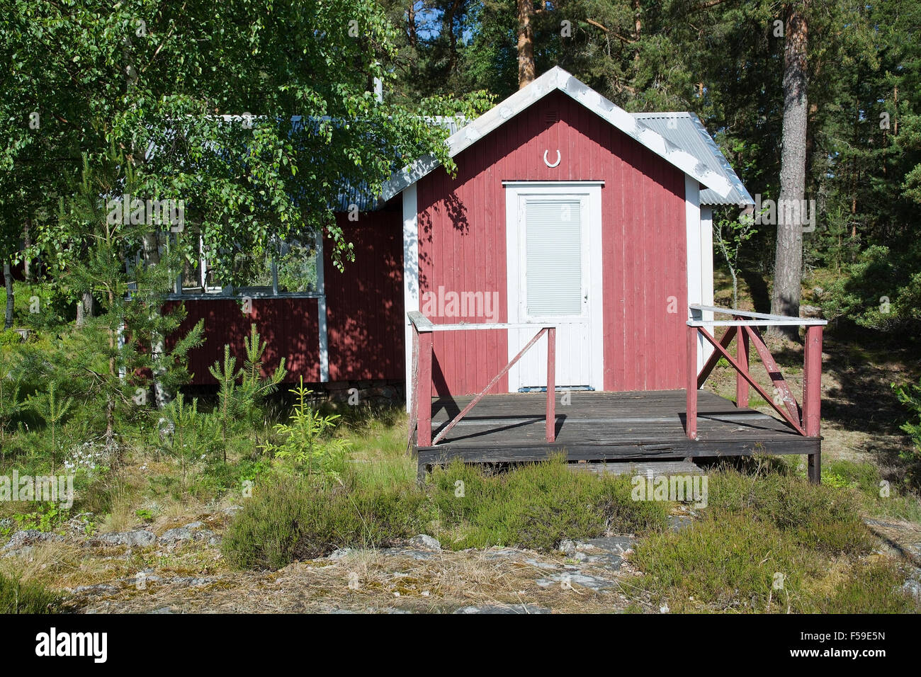 Rote Hütte, schöne rote typische Holz Sommerstil, mit Hufeisen über Tür in Värmland, Schweden. Stockfoto