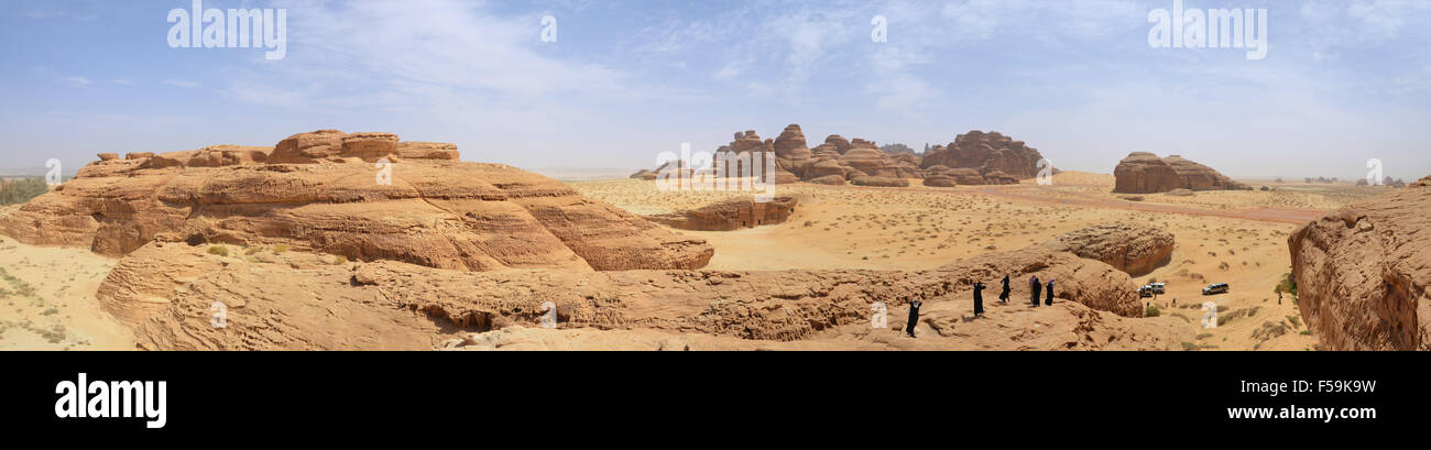 Gruppe von Menschen auf einem Berg in der Wüste, surreale Landschaft, off-Road-Fahrzeuge im Hintergrund Stockfoto