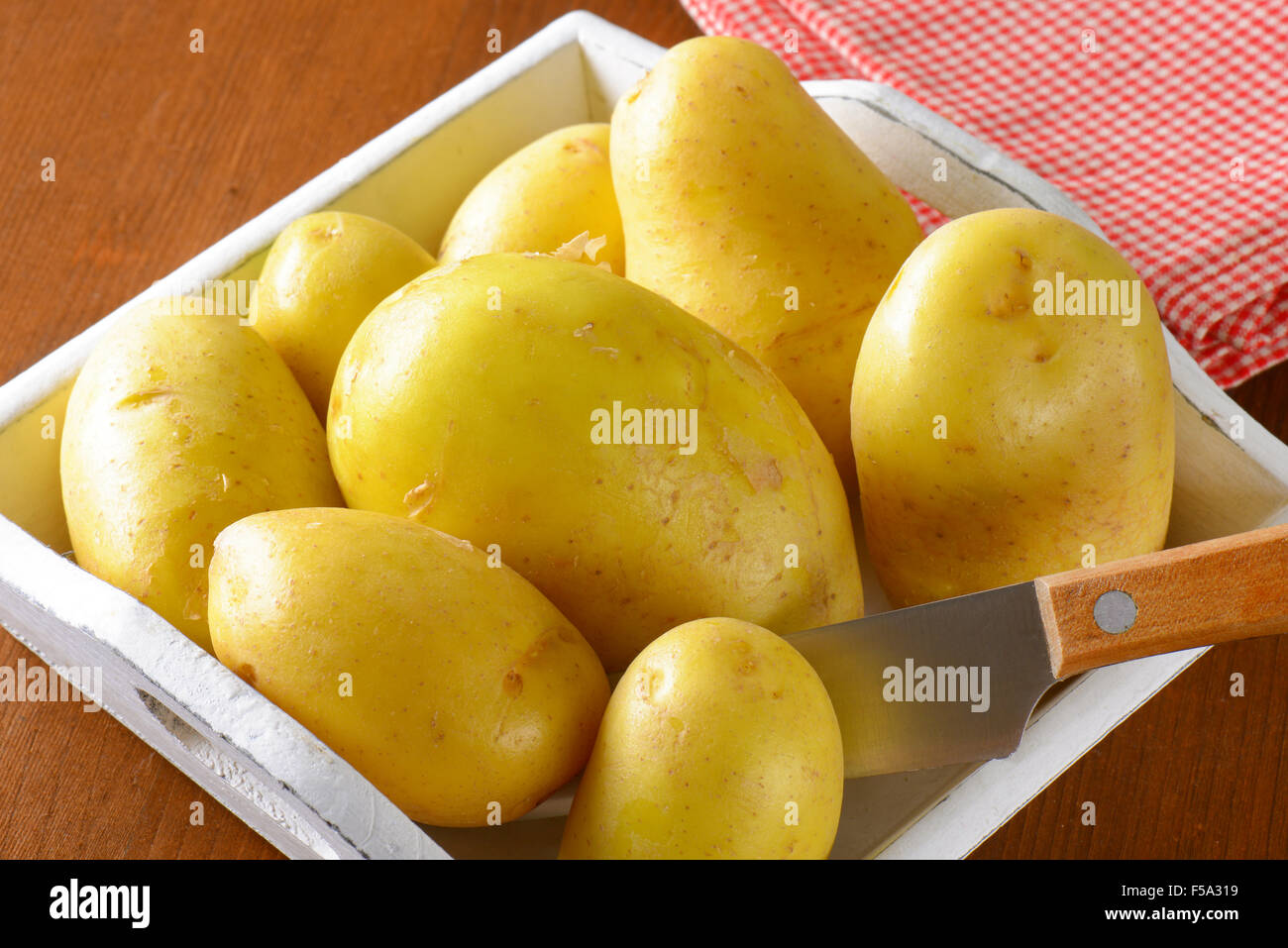 Neue Kartoffeln in weißes Holztablett Stockfoto