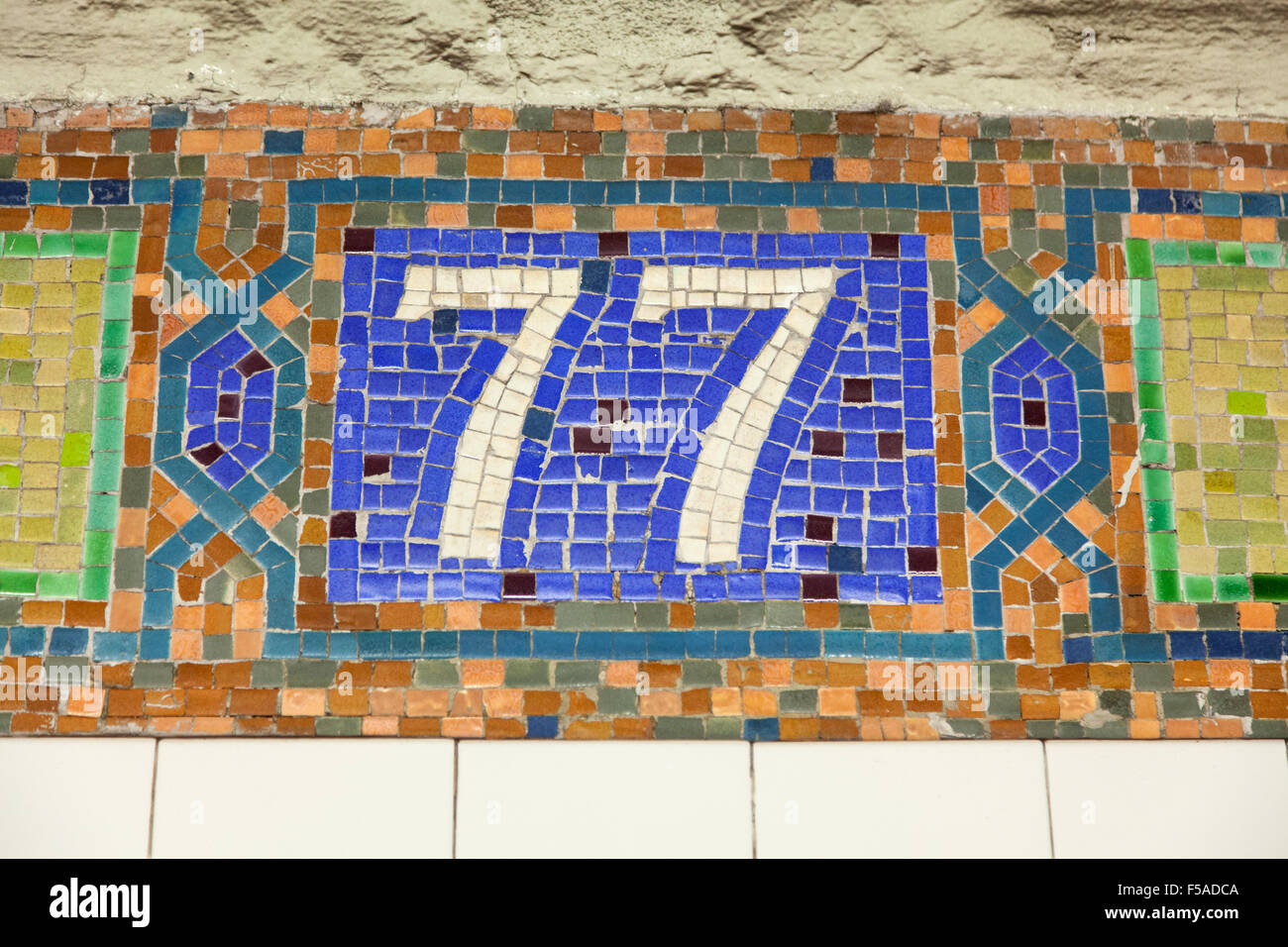 Mosaik Fliesen Zeichen für u-Bahnstation 77th Street, New York City, Vereinigte Staaten von Amerika. Stockfoto