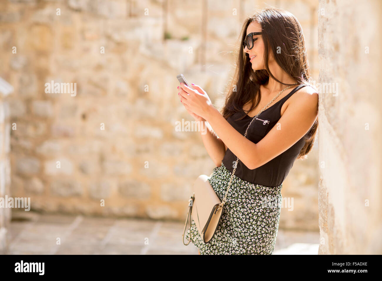 Hübsche junge Frau mit Handy Stockfoto