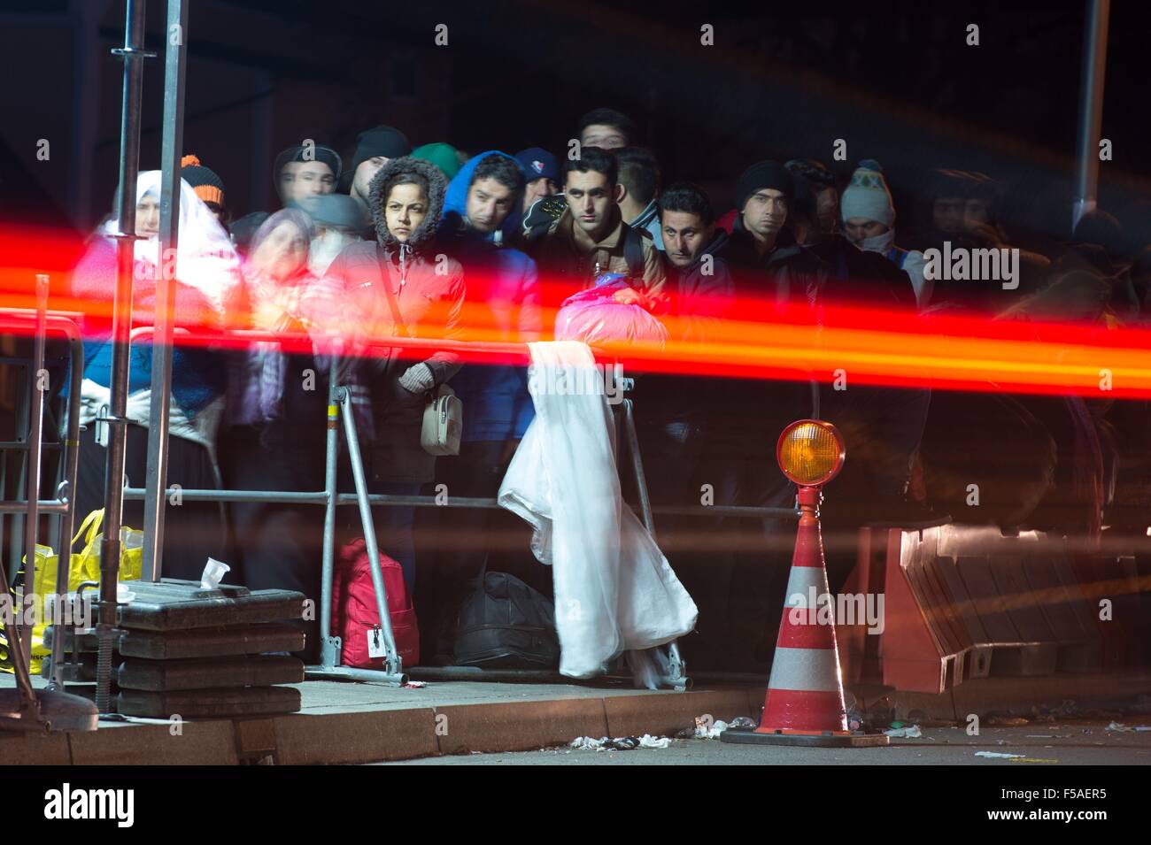 Flüchtlinge warten, da Autos vorbei an der deutsch-österreichischen Grenze in Simbach Am Inn in Deutschland, 31. Oktober 2015 fahren. Foto: SEBASTIAN KAHNERT/DPA (Effekt durch Langzeitbelichtung) Stockfoto