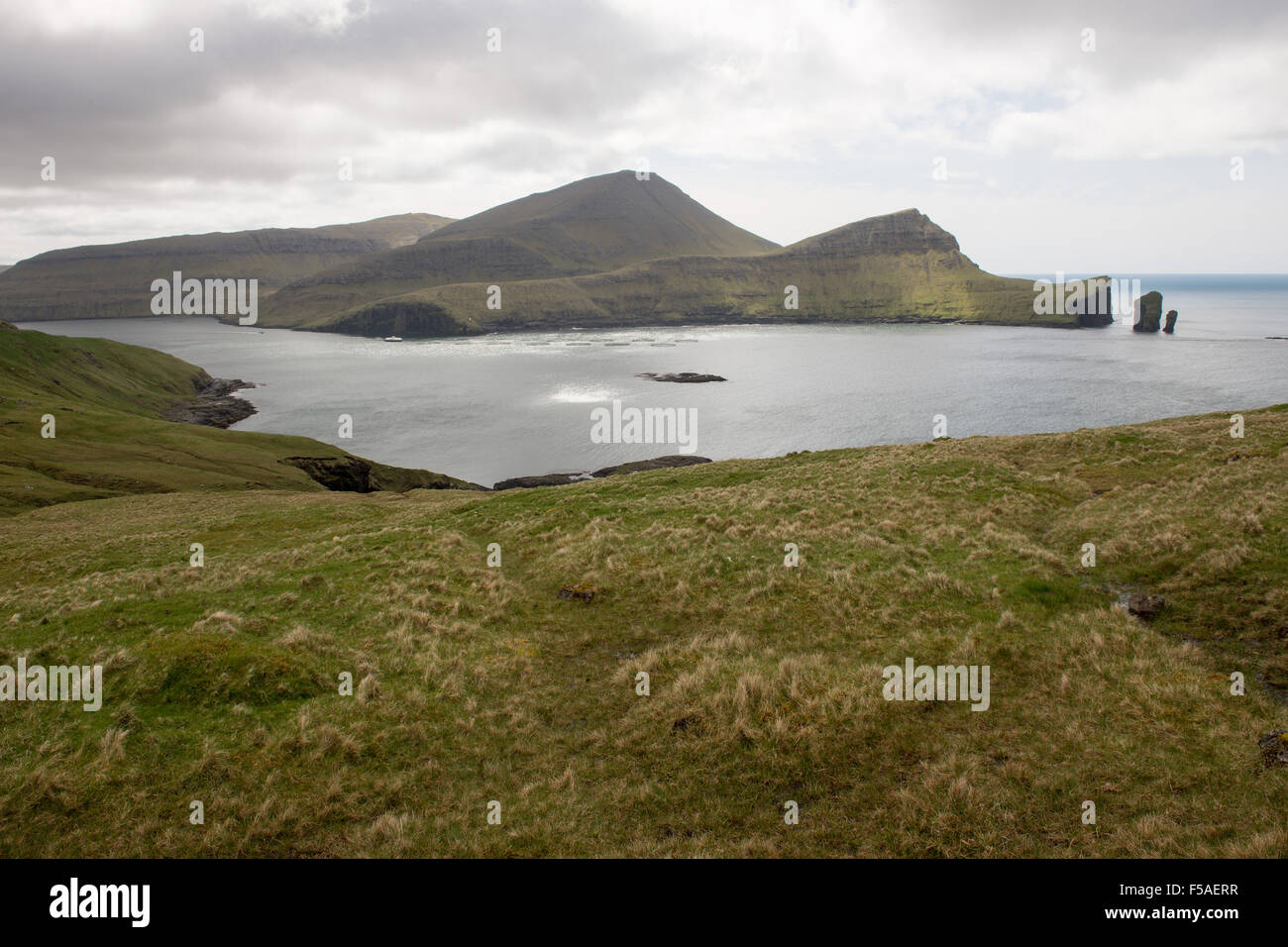 Klippen auf Vagar Insel auf den Färöern mit Lachs Farm Stockfoto