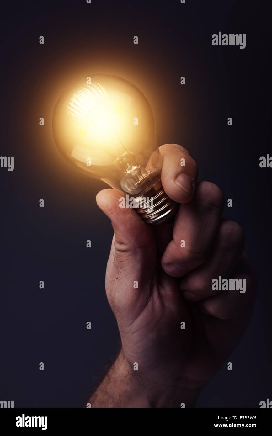 Kreative Energie und Kraft für neue Ideen, Innovation und Kreativität mit Hand Holding Glühbirne, getönten Retro Bild Stockfoto