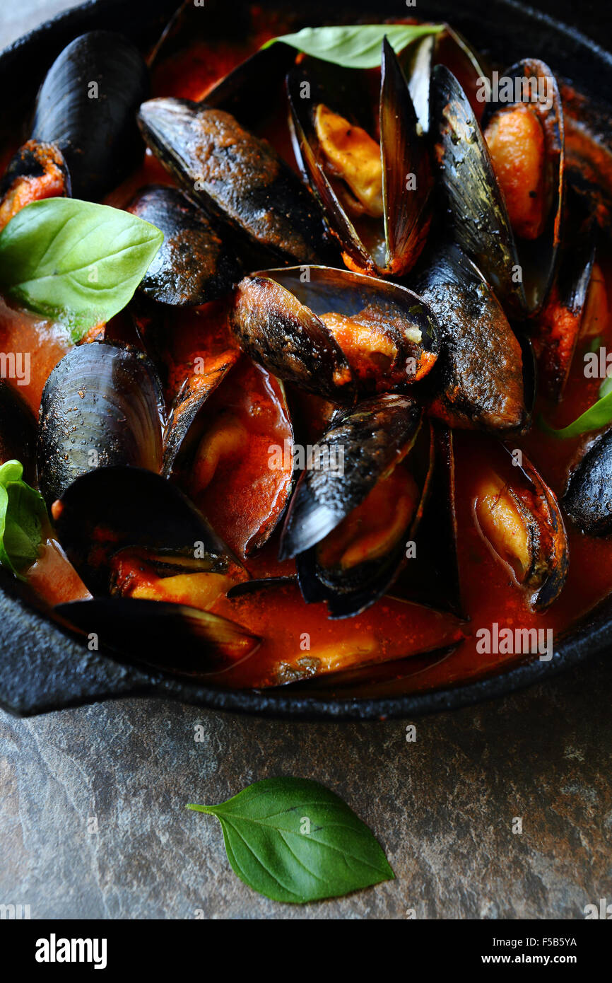 Muscheln in Tomatensauce mit Knoblauch, Essen Nahaufnahme Stockfoto