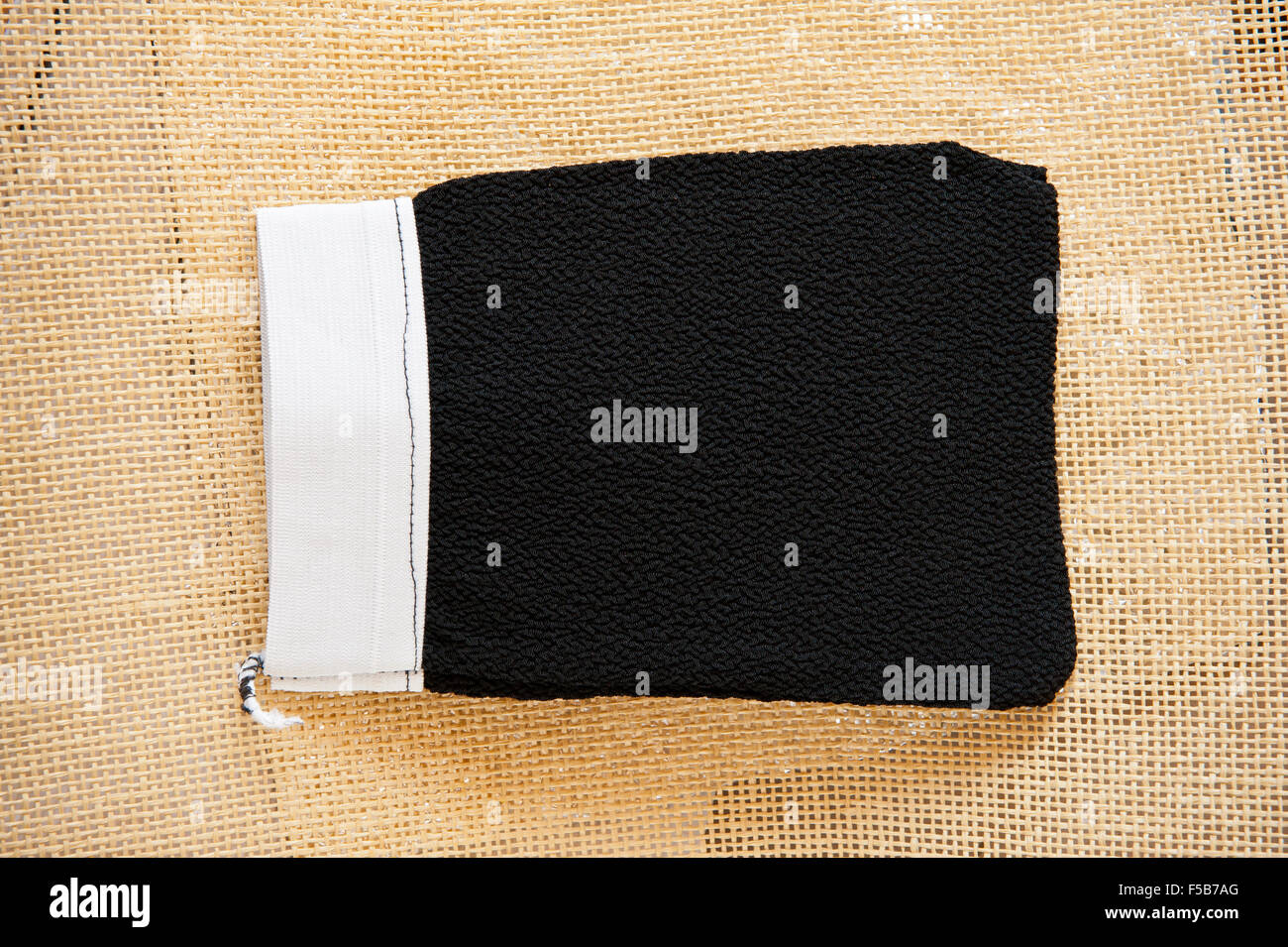 Marokkanische Peeling Kessa Handschuh für Hammam schrubben, schwarze Kessa grobe Krepp Materials liegen auf Matten, Pflege Körperpflege... Stockfoto
