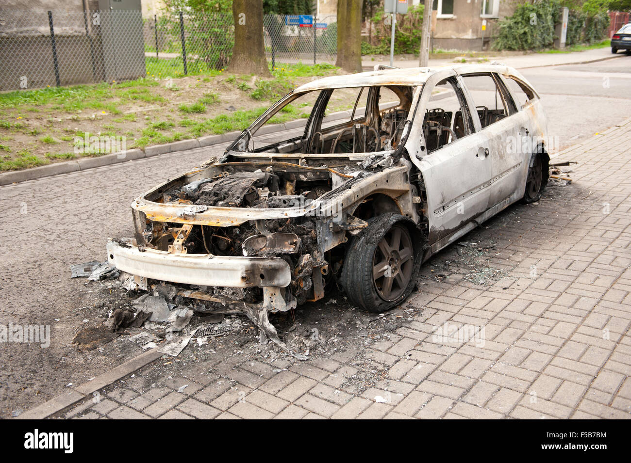 Verbrannte weißes Autowrack auf dem Bürgersteig in Polen, verwöhnte Auto in Feuerunfall, verkohlte Asche Brandstiftung Vorfälle und Junk-e-Fahrzeug... Stockfoto