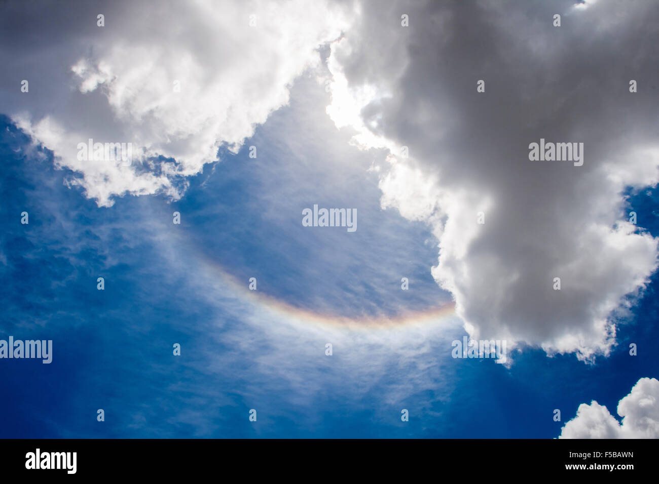 Regenbogen am Himmel gesehen, zwischen zwei Wolken Stockfoto