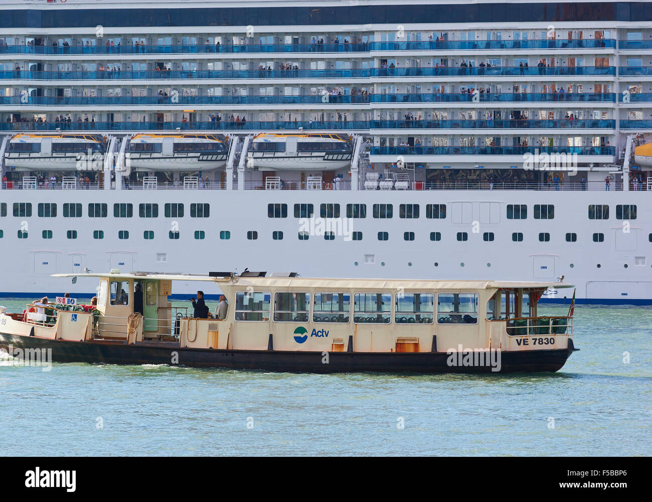 Riesige Kreuzfahrtschiff und Vaporetto (Wasserbus) nebeneinander in der venezianischen Lagune Venedig Veneto Italien Europa Stockfoto