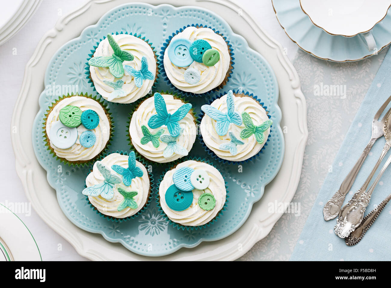 Cupcakes mit Sugarpaste Schmetterlinge und Knöpfen verziert Stockfoto