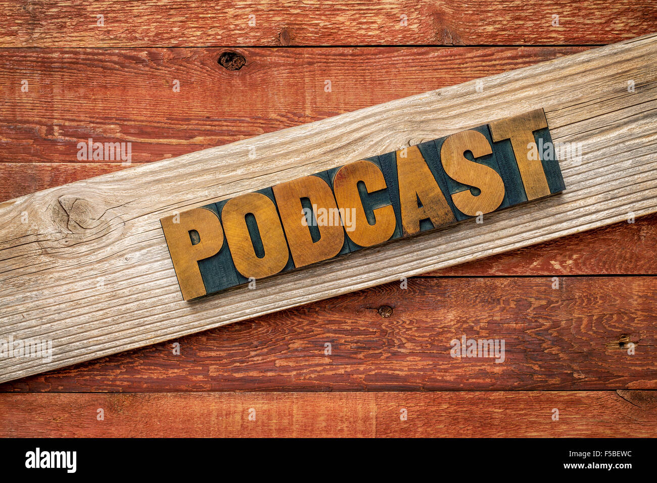 rustikale Zeichen Podcast - Buchdruck Holzart über gemaserte Zedernholz Plank gegen rote Scheune Holz Stockfoto