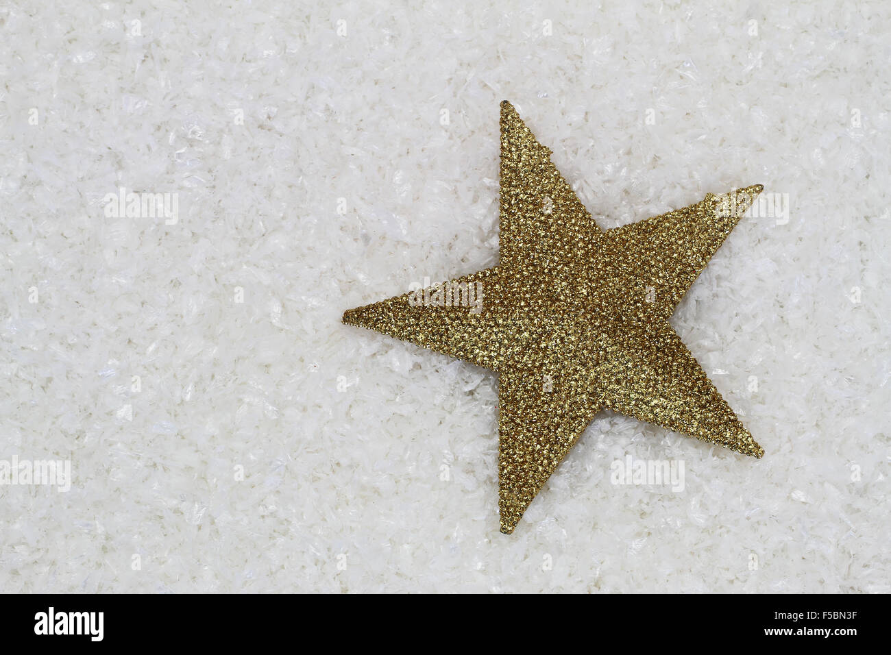 Sterne fallen mit goldenen Glitzer auf verschneiten Oberfläche mit Textfreiraum Stockfoto