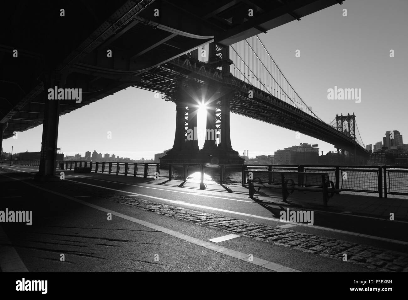 Die Sonne geht über Brooklyn und wirft Schatten auf den East River Esplanade, New York Stockfoto