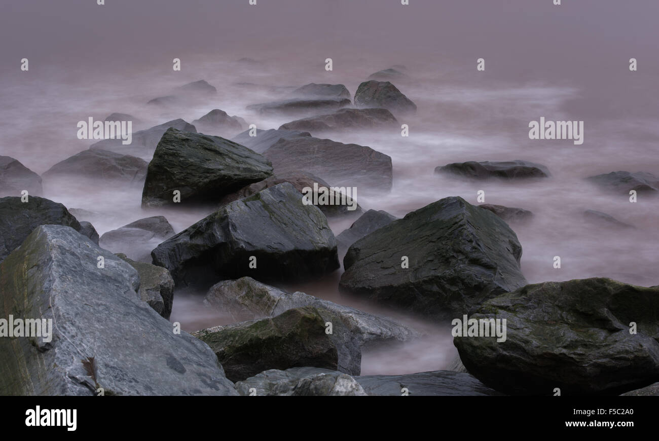 unheimliche nebligen Wellen rund um große Felsen Stockfoto