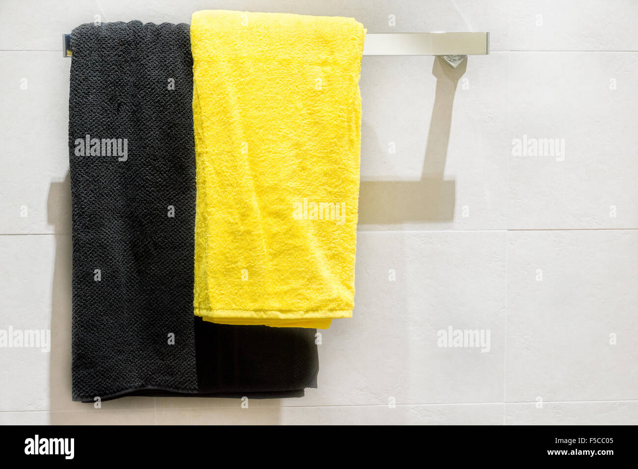 Schwarz-gelben Handtuch auf Kleiderbügel im Badezimmer Stockfoto