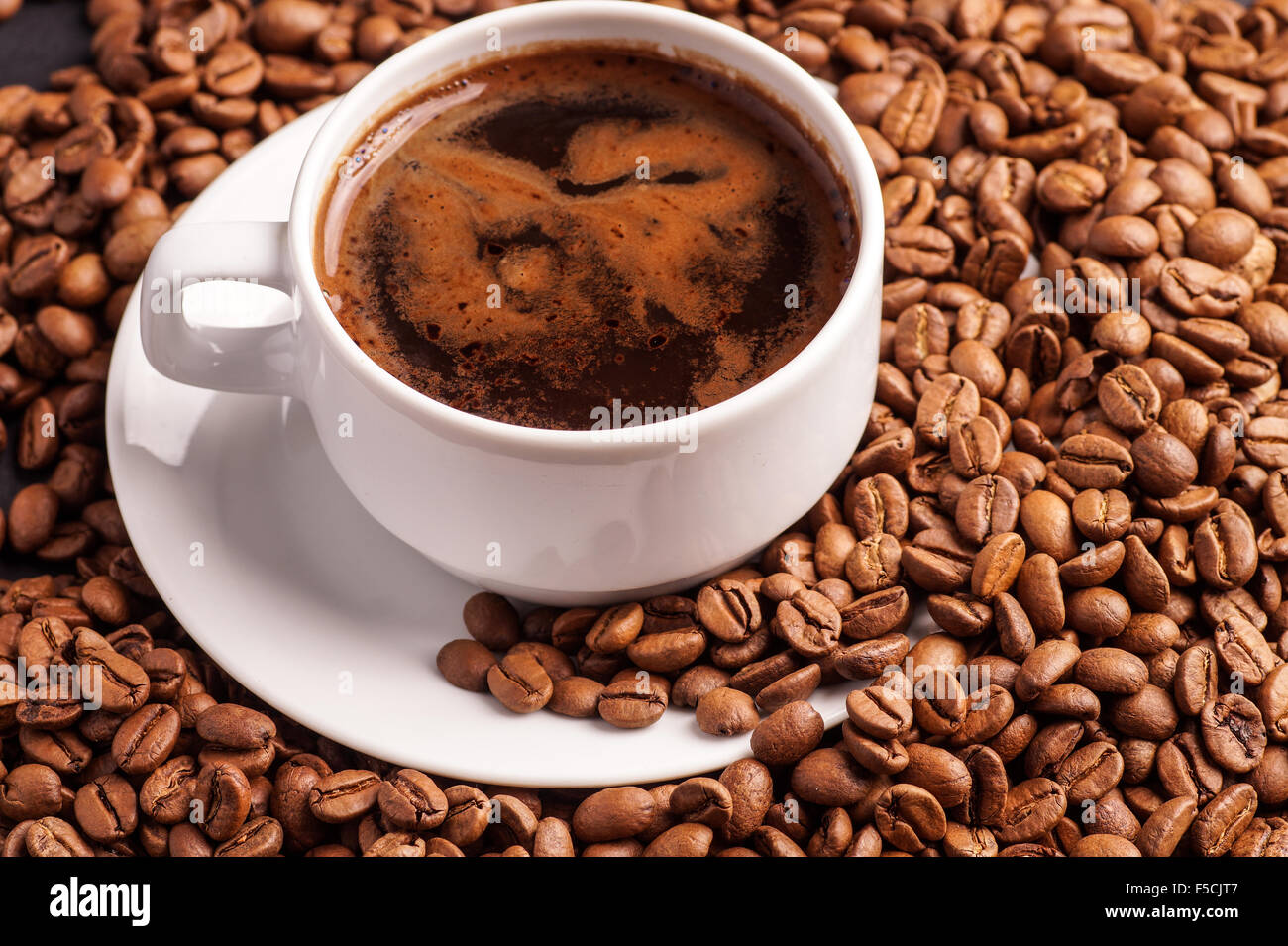Kaffee in eine Tasse und ein Haufen von Kaffebohnen Stockfoto