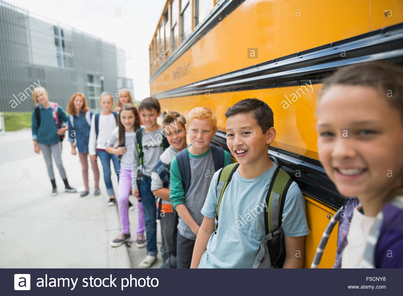 Porträt, Lächeln Schulkinder stützte sich auf Schulbus Stockfoto