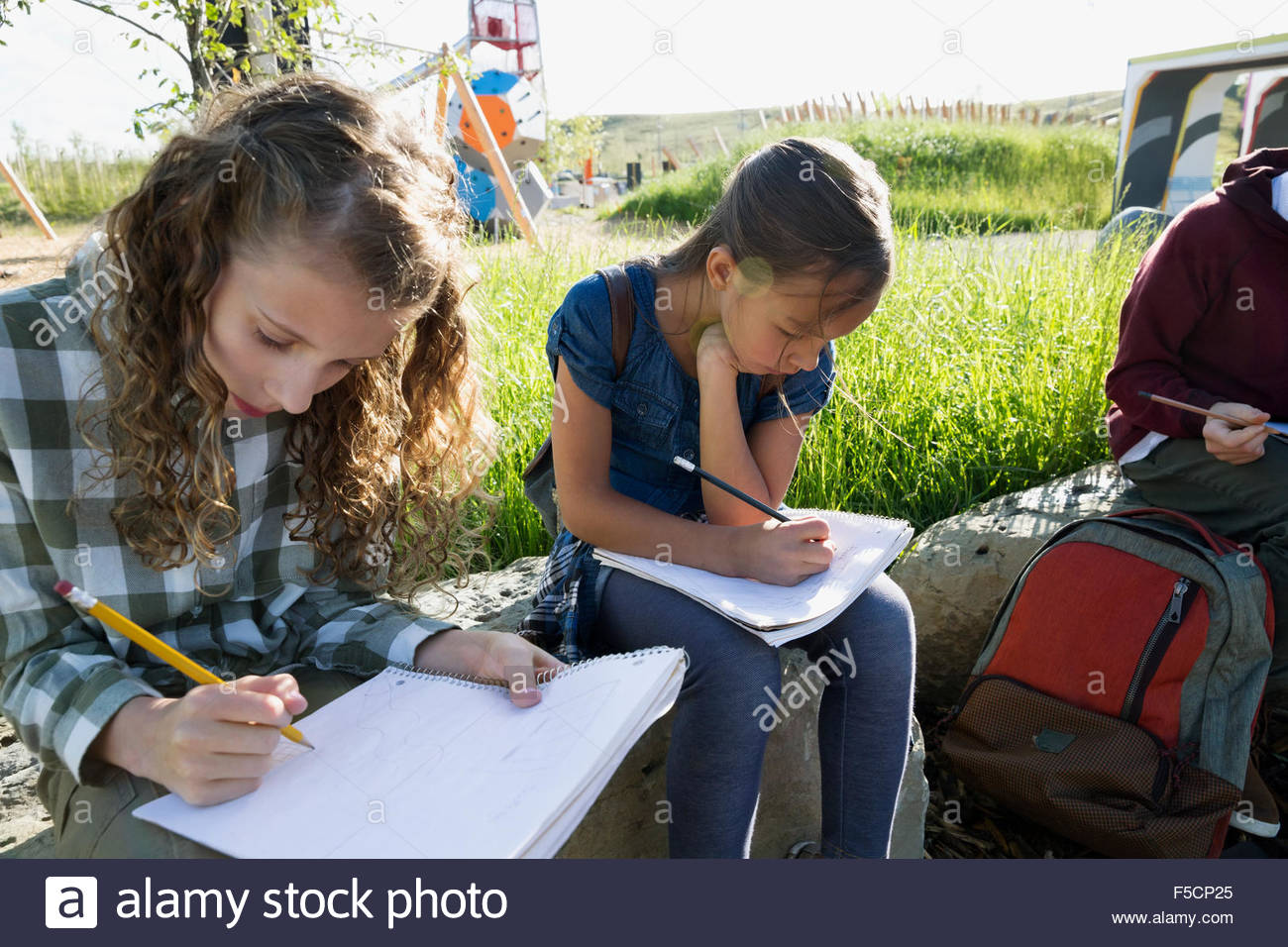 Studenten, die Hausaufgaben auf sonnigen Spielplatz Stockfoto
