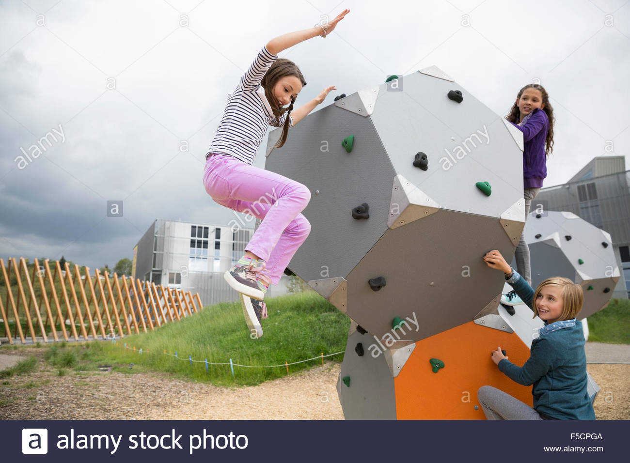 Mädchen, die einen Sprung von geometrischen Form am Spielplatz Stockfoto