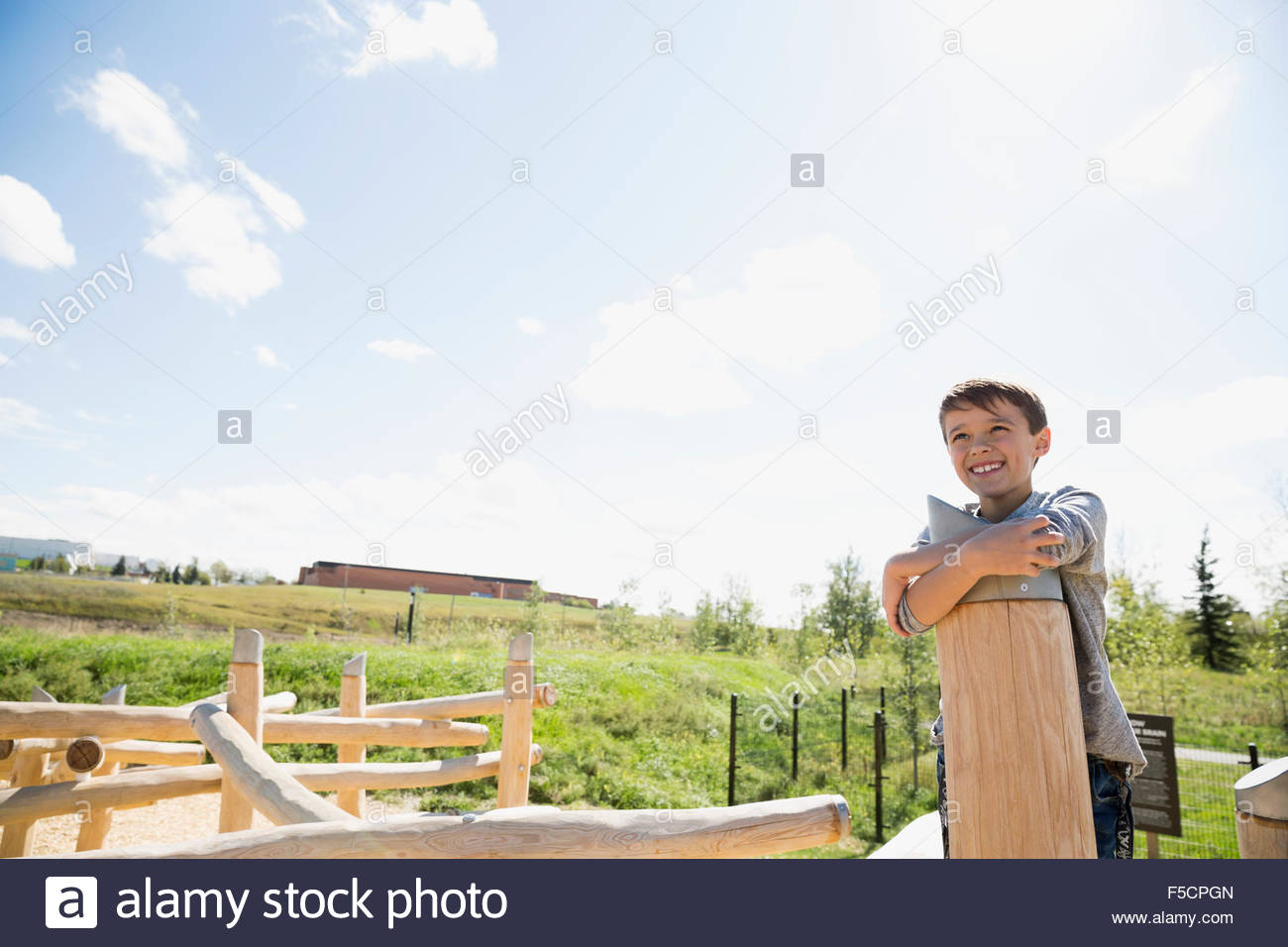 Unbeschwerte junge umarmt Post auf sonnigen Spielplatz Stockfoto