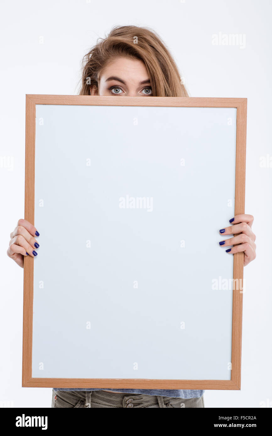 Porträt einer jungen Frau guckt über leere Brett isoliert auf weißem Hintergrund Stockfoto