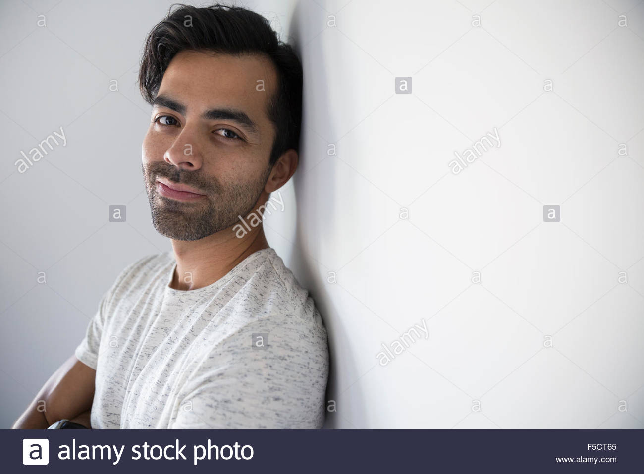Porträt, Lächeln, Mann mit schwarzen Haaren und Stoppeln Stockfoto