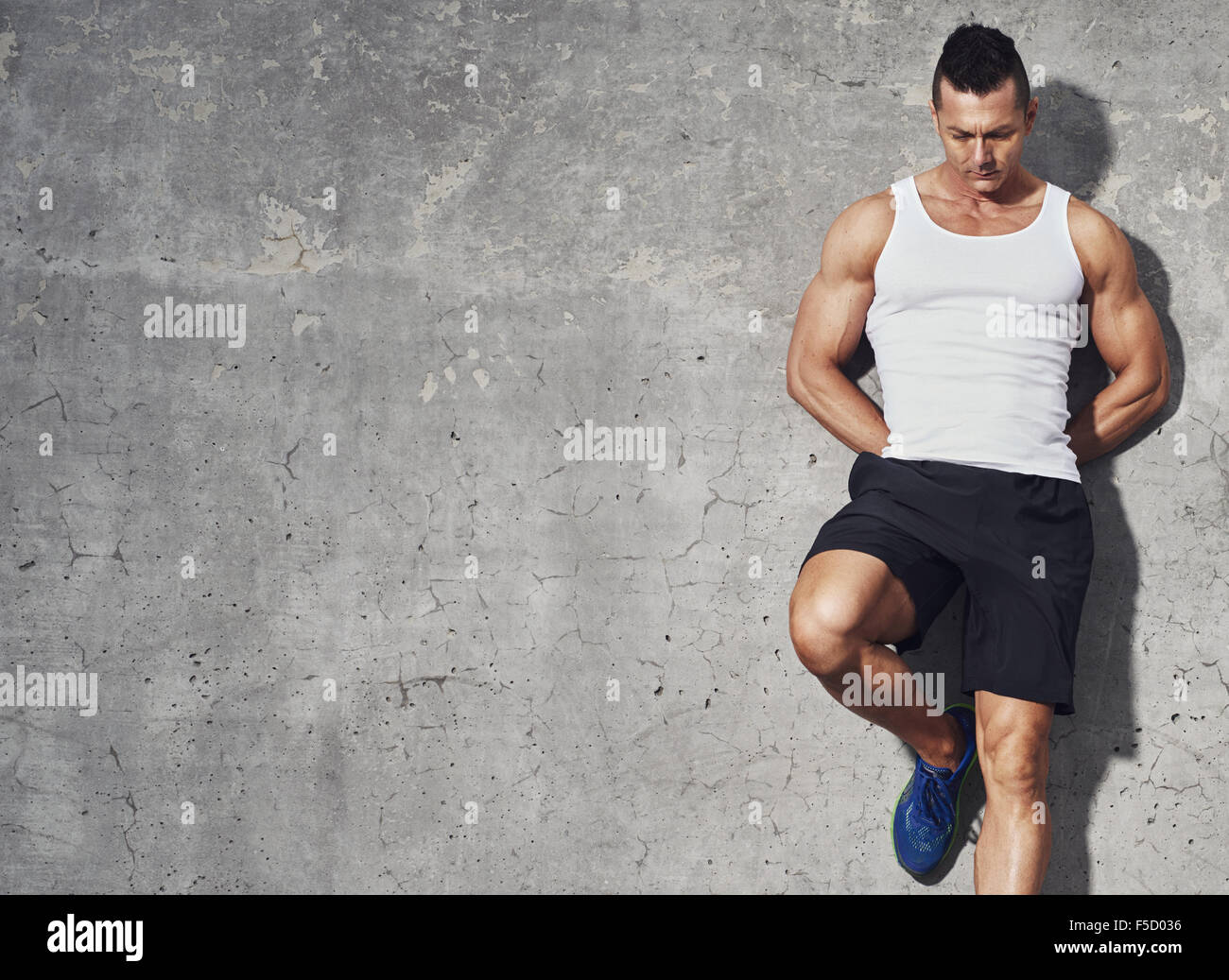 fitness-modell-mann-stand-vor-grauem-hintergrund-ein-bein-angewinkelt-an-wand-blickte-textfreiraum-f5d036.jpg