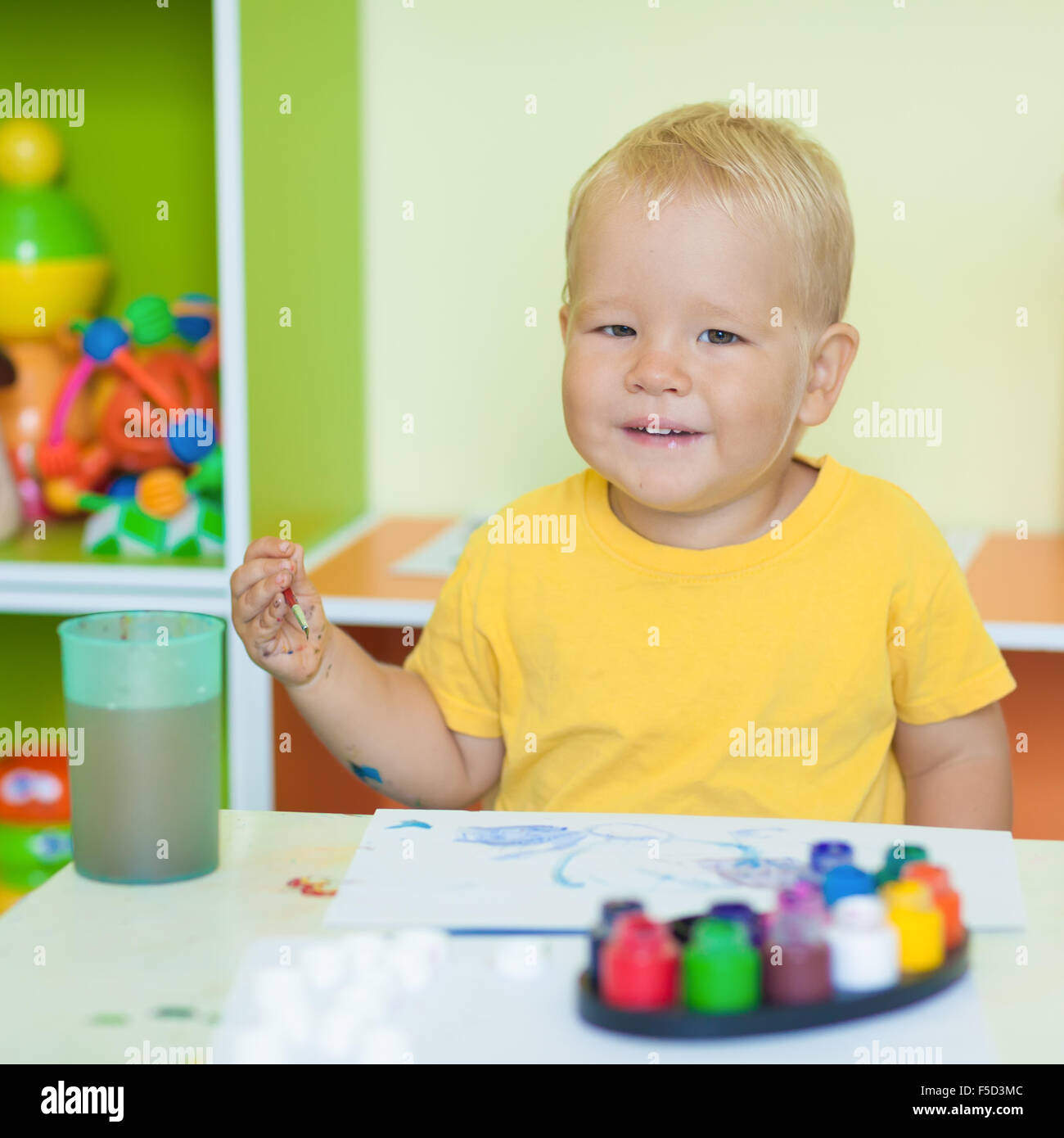 Kleinkind Jungen Praxis auf dem Papier sitzt am Tisch im Kinderzimmer malen Stockfoto