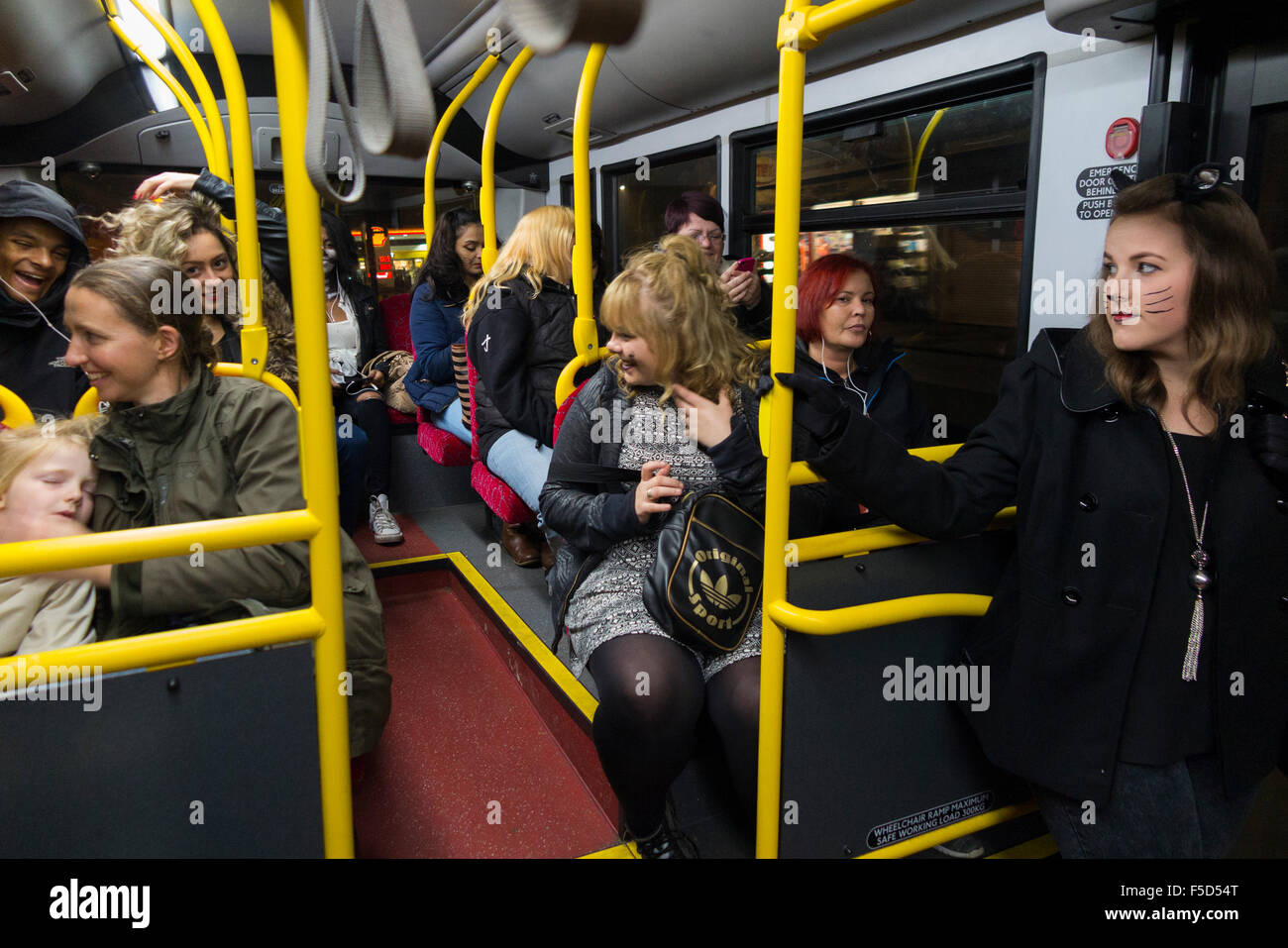 Bus-Passagiere glücklich / hohe Laune auf eine London Transport / LT bus in der Nacht / dunkel. Einige befinden sich im Kostüm Halloween-Stil. Stockfoto Bus-Passagiere glücklich / hohe Laune auf eine London Transport / LT bus in der Nacht / dunkel. Einige befinden sich im Kostüm Halloween-Stil. Stockfoto