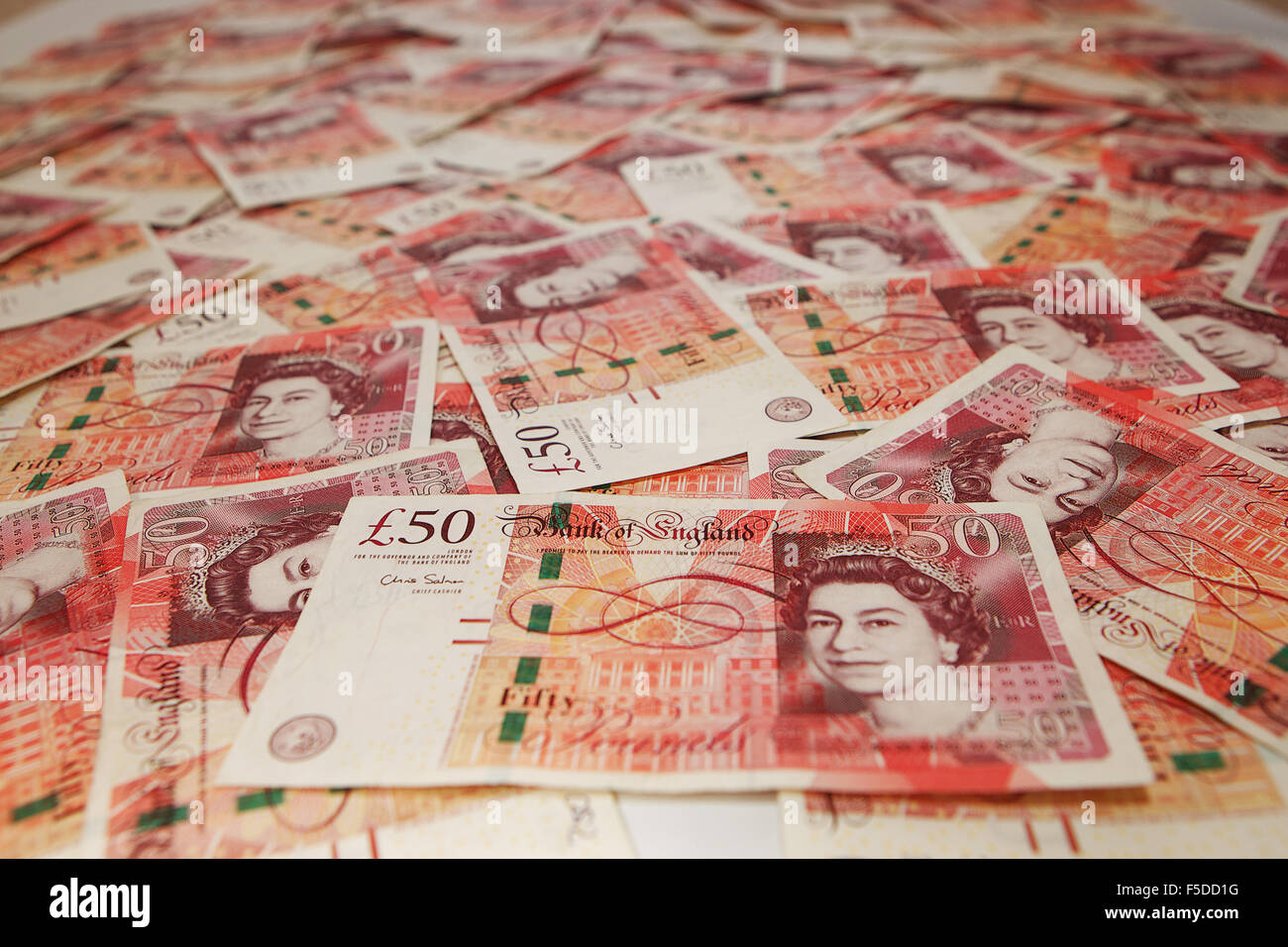 Haufen von £50 Noten verteilt Stockfoto