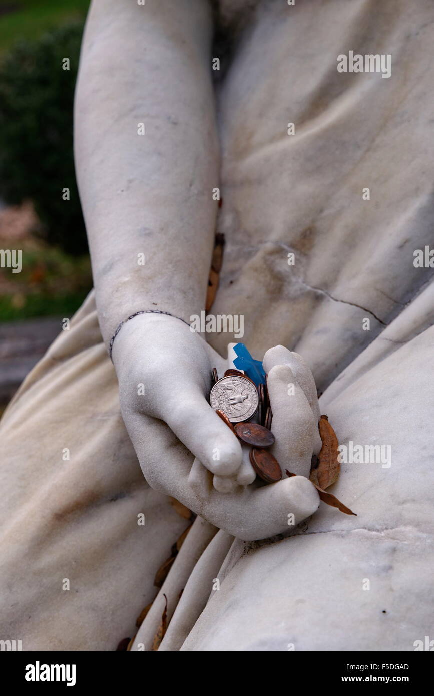 Friedhof-Statue mit Münzen in der Hand Stockfoto