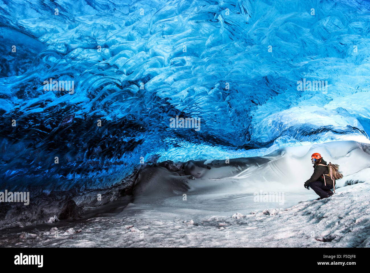 Mann-Reisenden exotischen Wahrzeichen, sitzen in der Eishöhle, Skaftafell Gletscher Vatnajökull-Nationalpark, herrliche Natur genießen Stockfoto