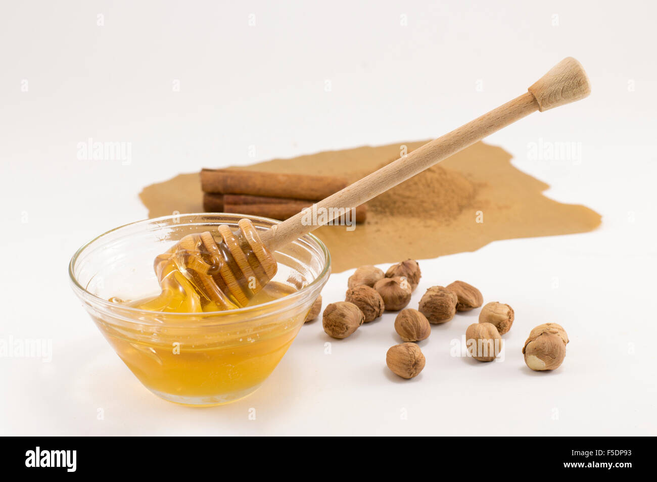 Haselnüsse, Honig und Zimt auf einen weißen Tisch. Gesunder Winter behandelt Stockfoto