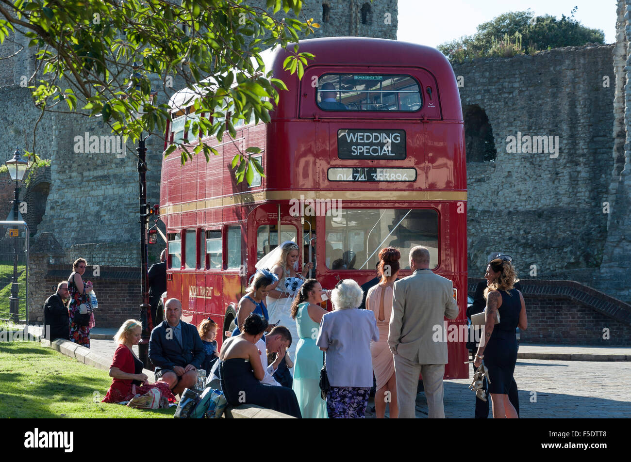 Hochzeit Braut und Gruppe von Routemaster Bus, Rochester Castle, Rochester, Kent, England, Vereinigtes Königreich Stockfoto