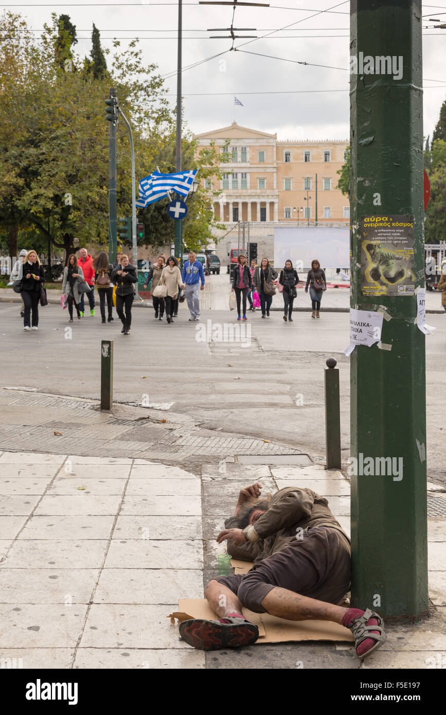 Athen, Griechenland - 31. Oktober 2015: Bettler schlafend auf dem Syntagma-Platz, mit Blick auf das griechische Parlament Stockfoto