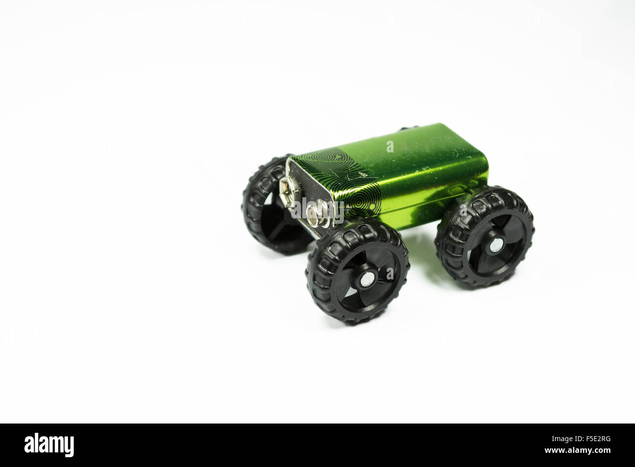 Kleine Batterie platziert auf einem Set o-Kunststoff-Räder, Konzeptbild über Elektro-Auto, isoliert auf weiss Stockfoto