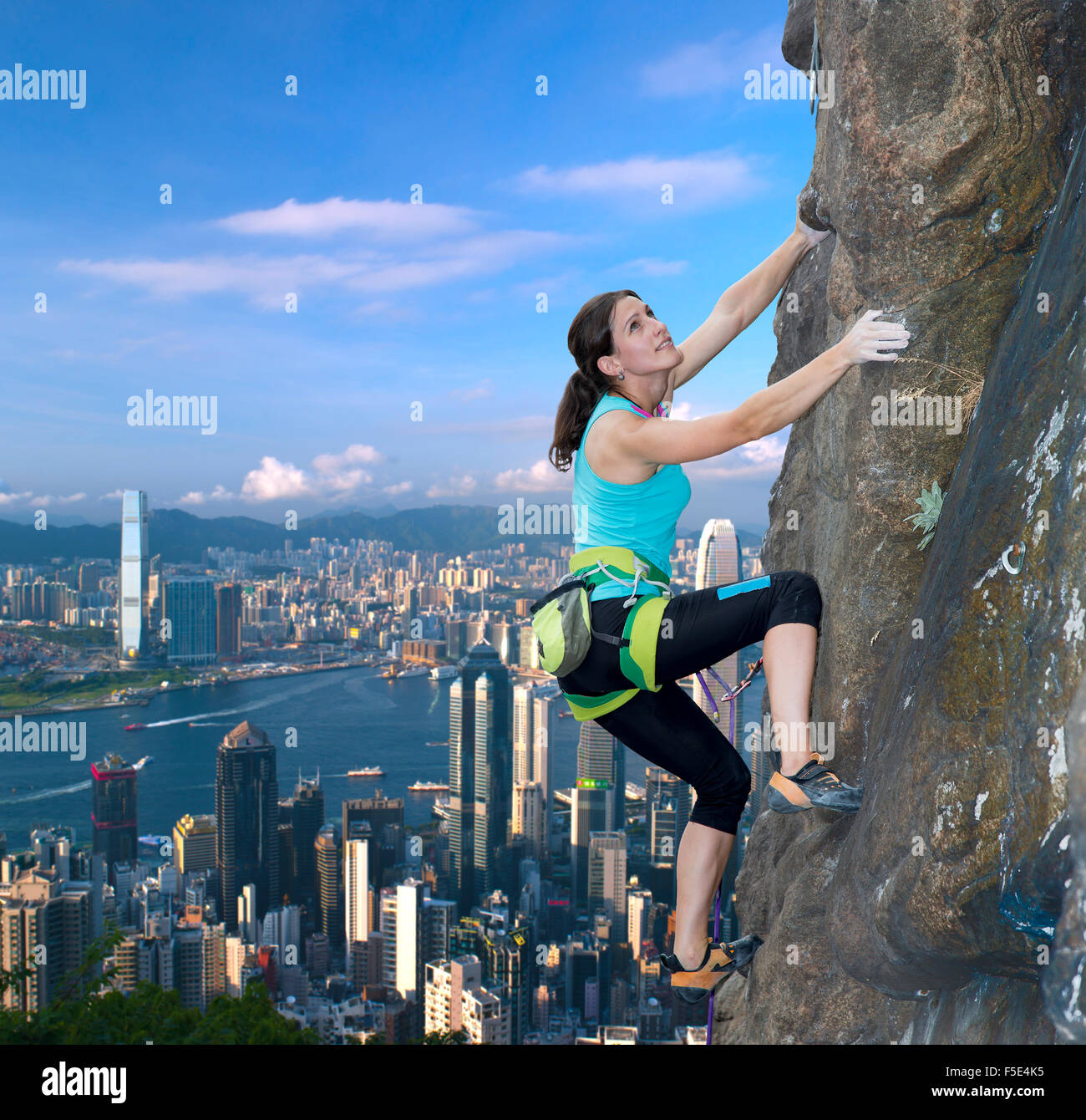 Weibliche Kletterer über die Skyline der Stadt Stockfoto