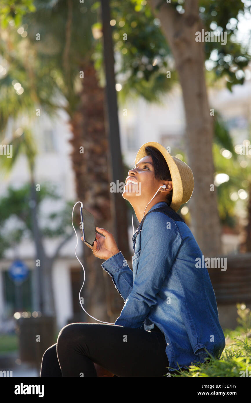 Porträt einer schönen jungen Frau anhören von Musik auf dem Handy Stockfoto