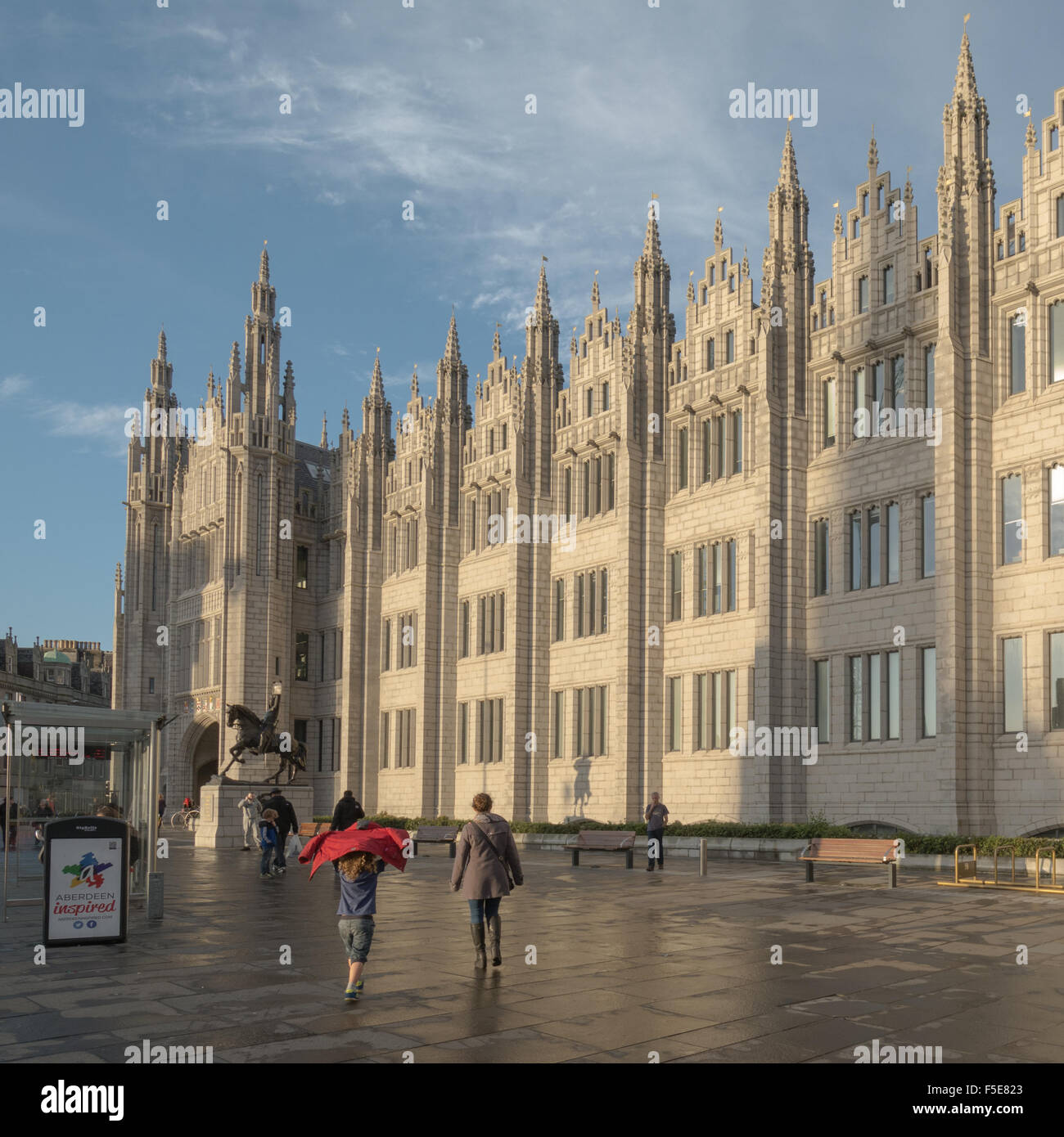 Familie zu Fuß in Richtung Marischal College, der Sitz des Stadtrates von Aberdeen bei Sonnenuntergang - Aberdeen, Scotland, UK Stockfoto