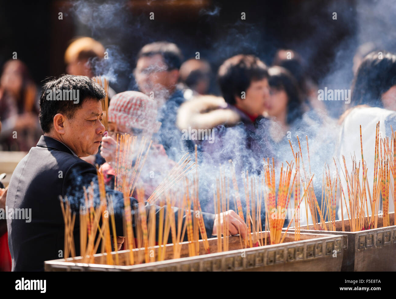 Menschen brennen Räucherstäbchen außerhalb Wong-Tai-Sin-Tempel, Kowloon, Hong Kong, China, Asien Stockfoto