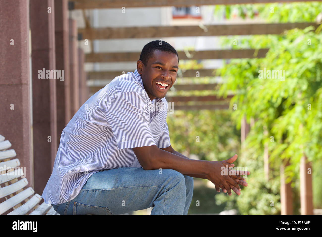 Seite Porträt eines jungen schwarzen Mann Lachen draußen Stockfoto