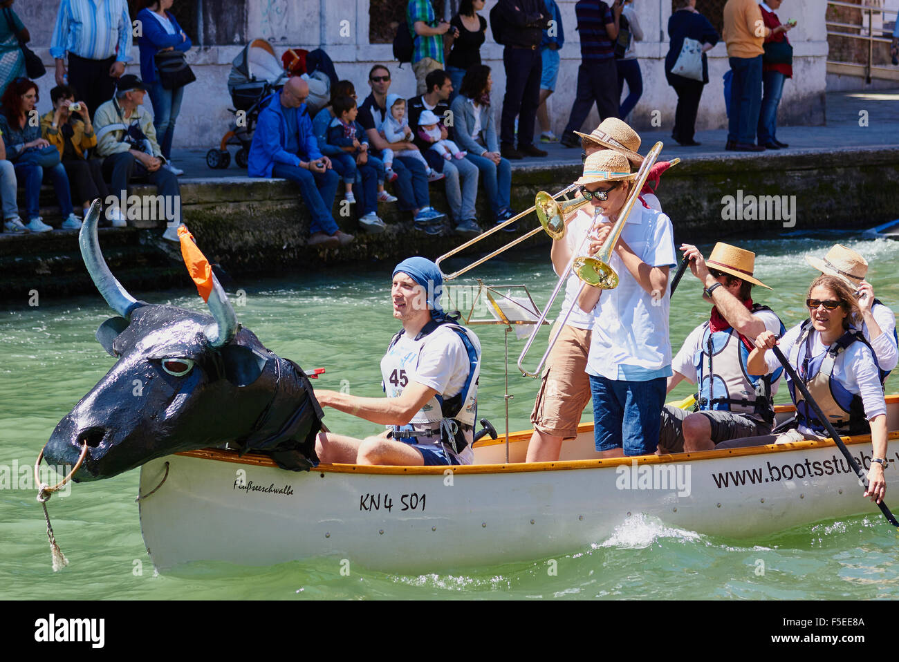 Ein Boot mit einem Bullen Kopf und zwei im Team spielen Trompeten, die Teilnahme an der Vogalonga Veranstaltung Venedig Veneto Italien dekoriert Stockfoto