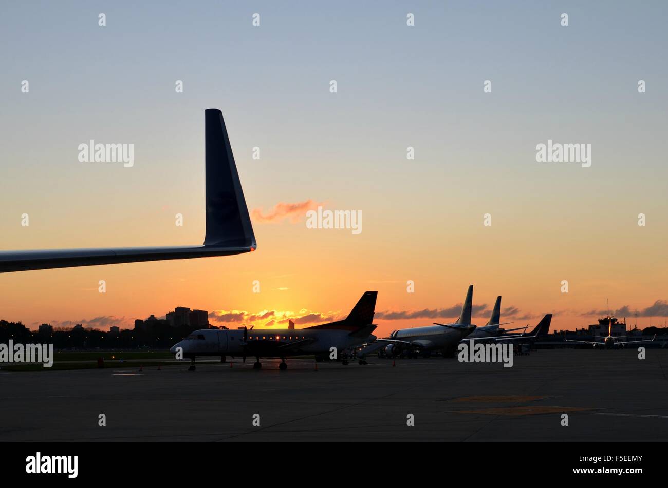 Flugzeuge in einer Reihe auf dem Flughafen bei Sonnenuntergang Stockfoto
