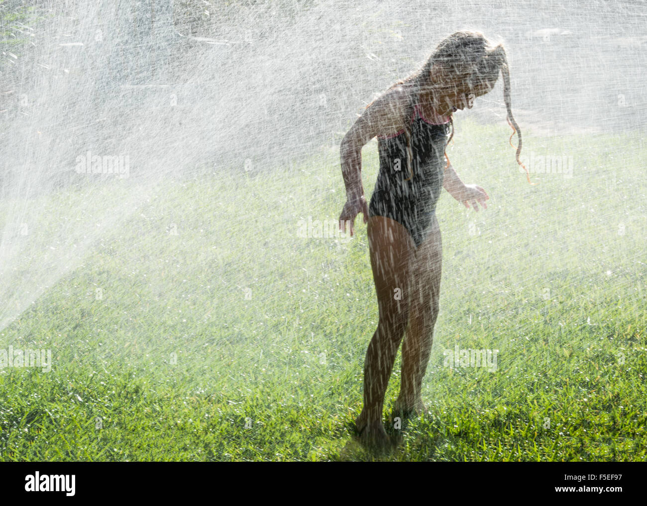 Mädchen stehen in einer Wasser-sprinkler Stockfoto Mädchen stehen in einer Wasser-sprinkler Stockfoto