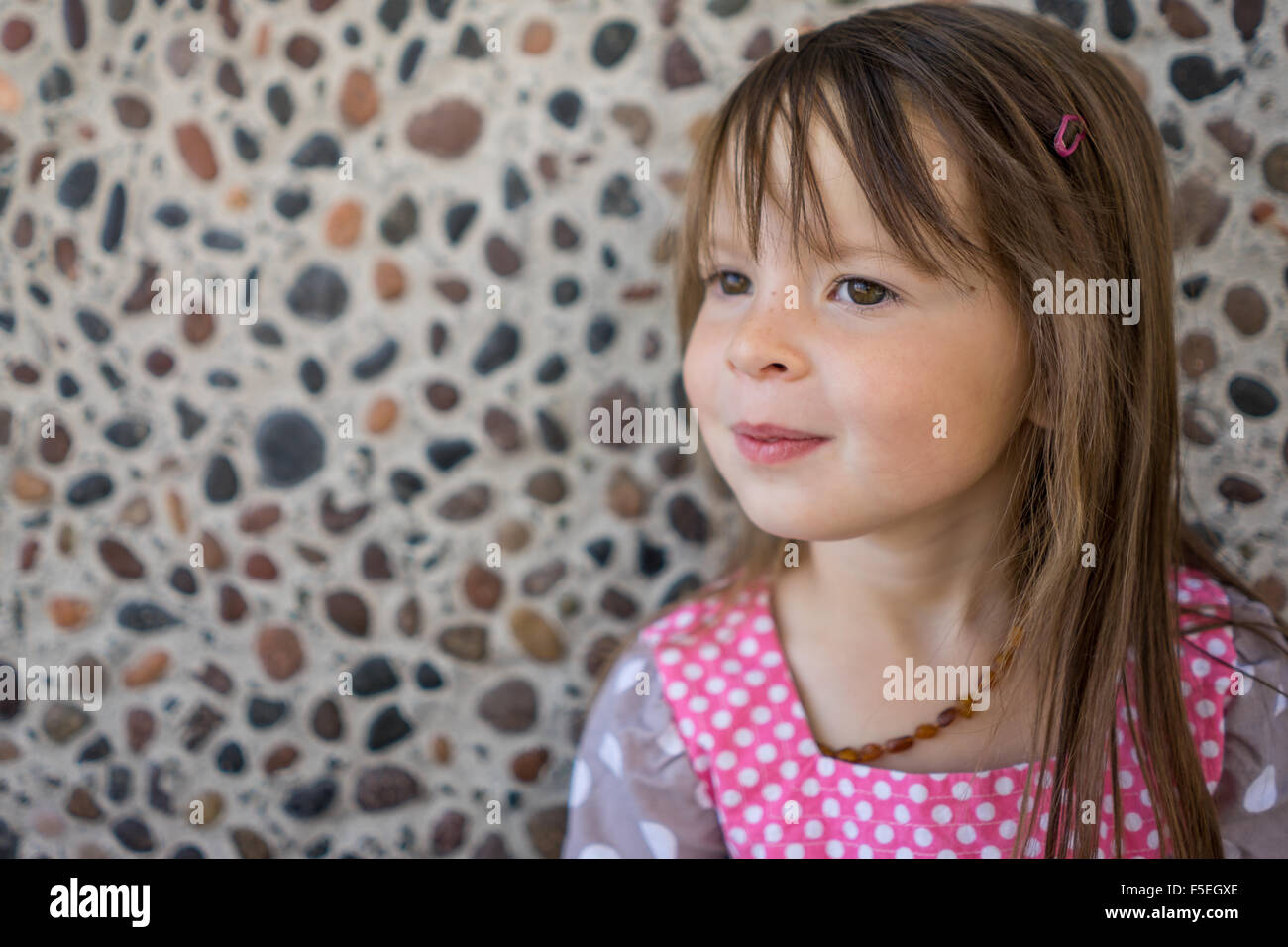 Porträt eines Mädchens stehend gegen eine Wand Kiesel Stockfoto