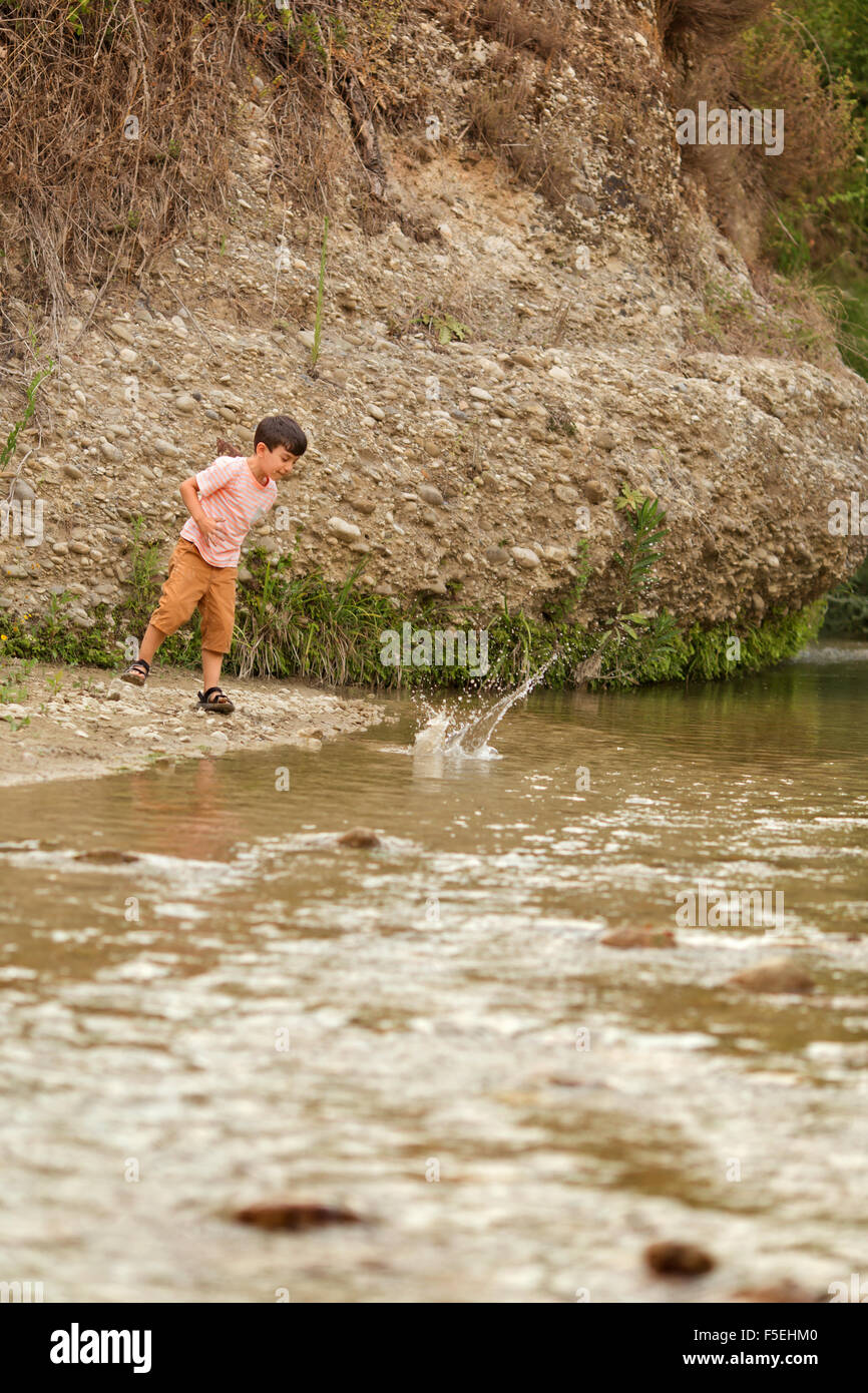 Junge werfen von Steinen in einem Fluss, Kato Samiko, Griechenland Stockfoto