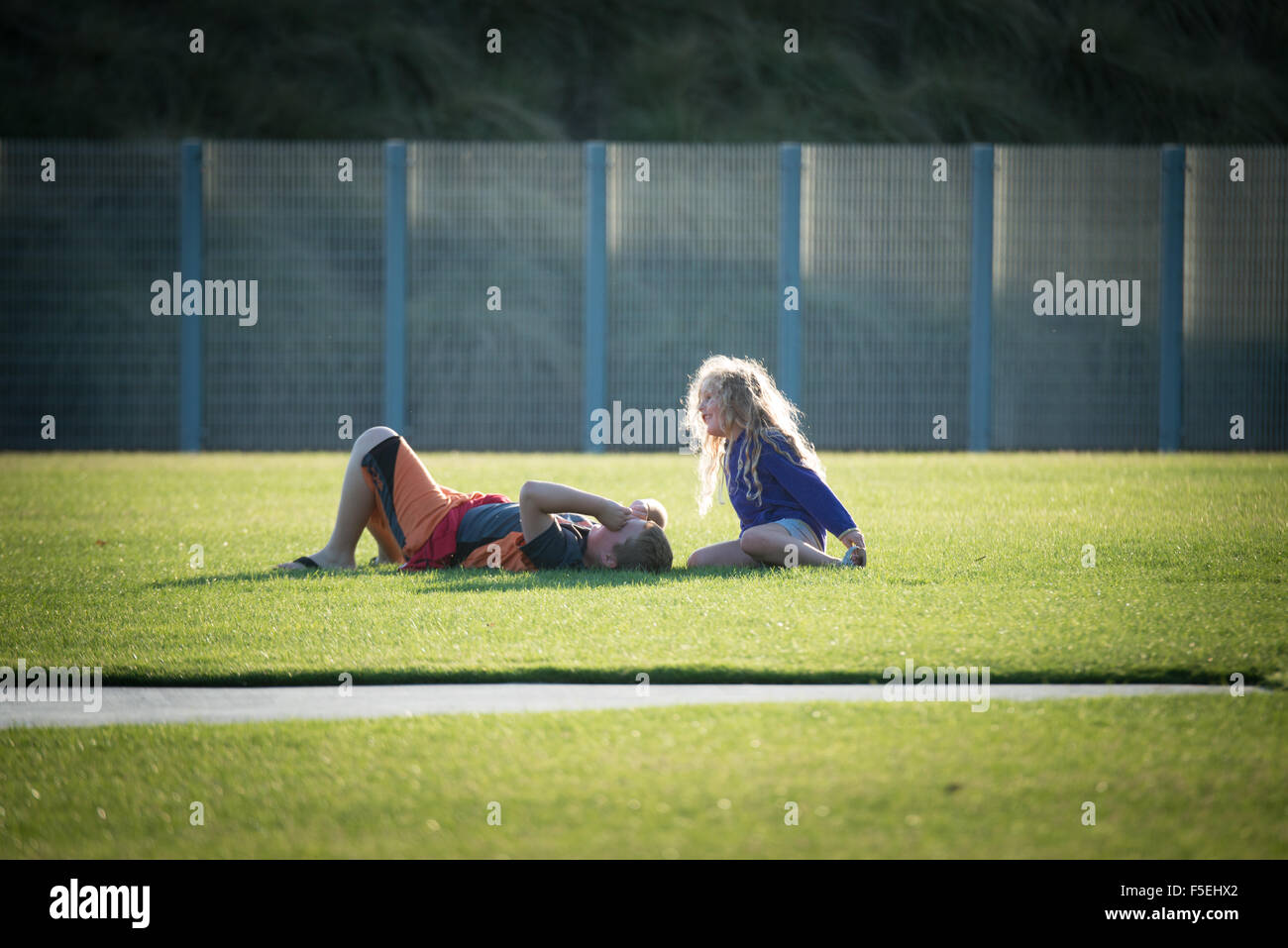 Jungen und Mädchen auf einem Fußballfeld im Gespräch Stockfoto