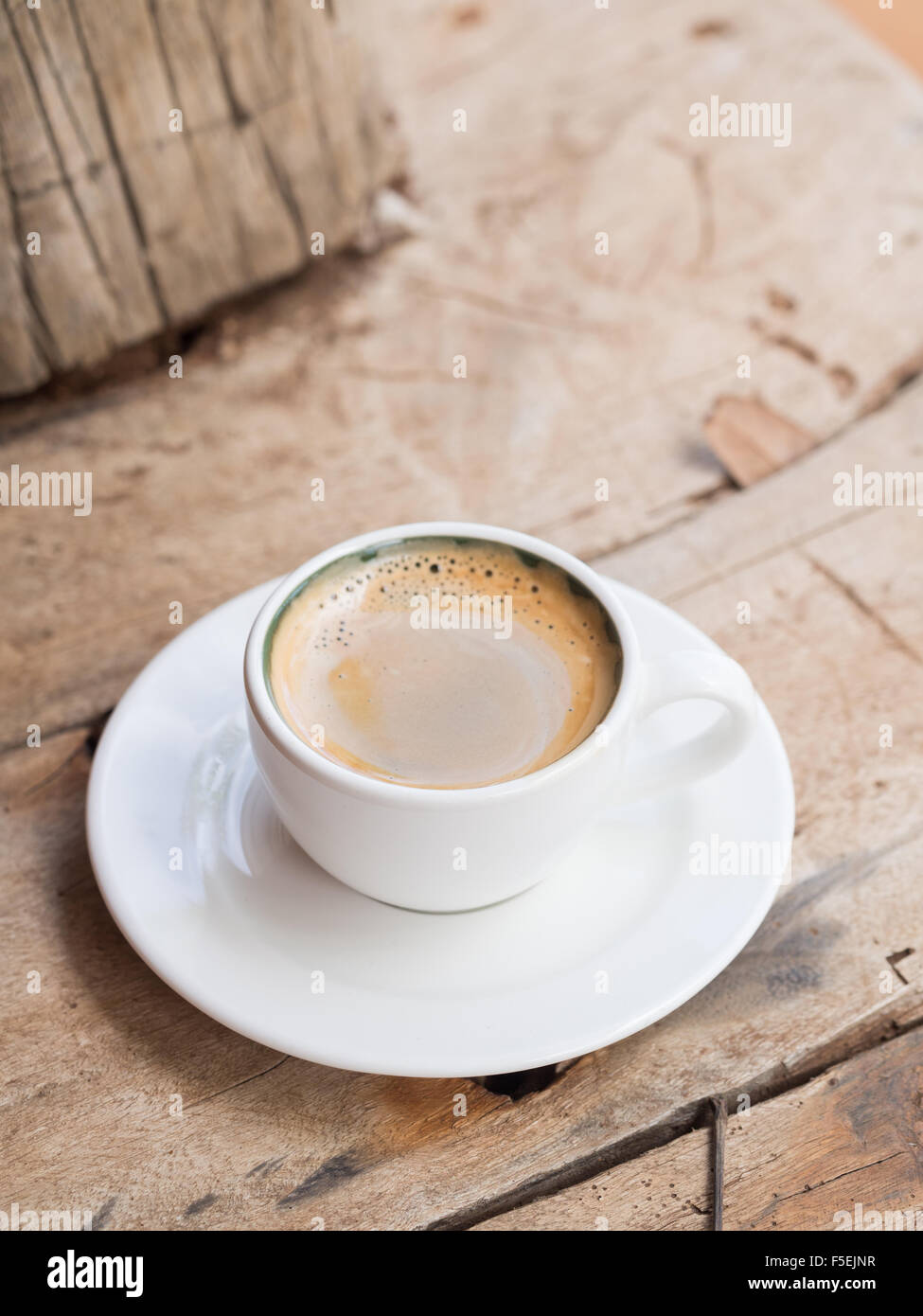 Doppelter Espresso in eine weiße Tasse über einem Dhau Holztisch gelegt. Erhöhten Blick, vertikale Ausrichtung. Stockfoto
