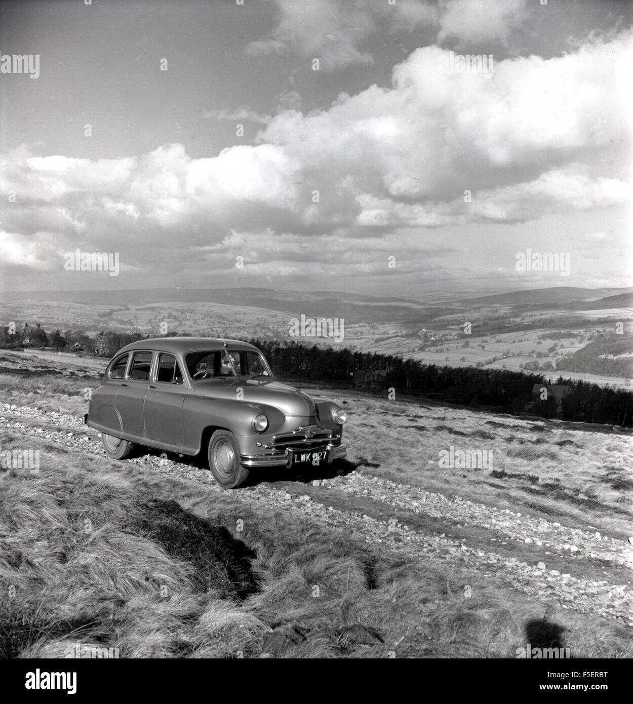 1950er Jahre historische Bild eines Standard Vanguard Autos auf einer Strecke von Landschaft. Es war Standard ersten Post zweiten Weltkrieg Auto. Stockfoto